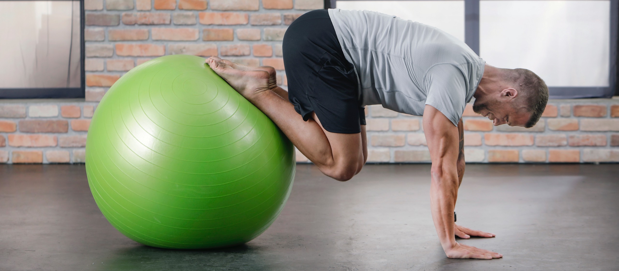 Trainer Martin bei Übung mit grünem BODYMATE Gymnastikball Studioloft