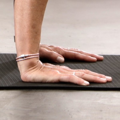 Zwei weibliche Hände stützen auf BODYMATE Yogamatte
